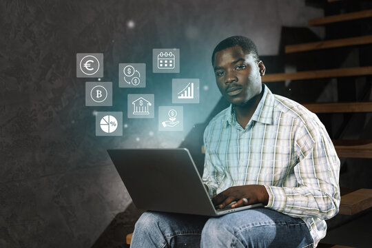 Young man working on laptop with digital icons, focused on online finance and data management in a modern workspace - Powered by Adobe