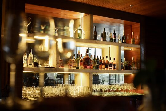 Restaurant bar or pub bar background with dim lights and champagne glasses in defocus