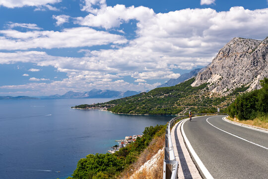A cyclist enjoys a ride on the spectacular Adriatic Highway along the mountain coast of the Makarska Riviera, Croatia.Stunning summer landscape of the Dalmatian coast