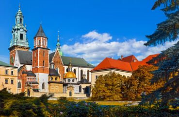 Krakow, Poland. Wawel castle towers of vintage fortress and Catholic temple. Picturesque territory in autumn day with yellow and green trees.