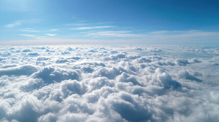 A panoramic view from an airplane over a bed of white fluffy clouds