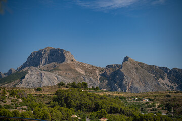 Serene mountain range with rural buildings in daylight