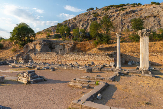 Roman forum ruins of Philippi with two standing columns and ancient walls at the foot of the acropolis hill