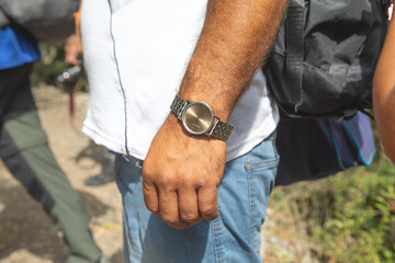 Caucasian young man wearing wristwatch in nature.