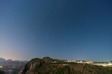 Serene night sky filled with stars over mountain landscape
