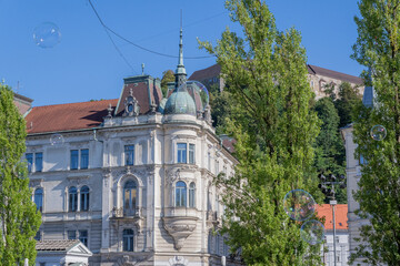 Elegant Historic Building in Ljubljana Framed by Trees and a Vibrant Blue Sky