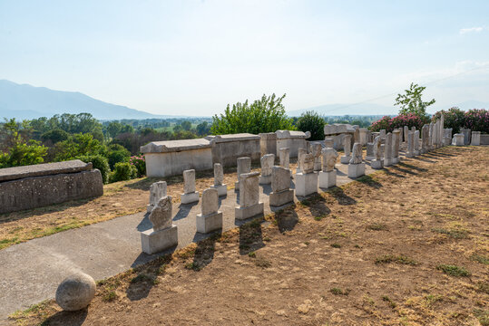 Row of ancient Greek and Roman stelae displayed on pedestals in the stone lapidarium, part of the Philippi archaeological complex