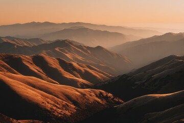 Naklejka premium Sunrise hues paint rolling mountain ranges