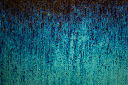 Abstract close-up texture of a blue and brown reactive glaze pottery. Artistic background