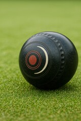 A close-up shot of a lawn bowling ball resting on vibrant green grass. This image captures the essence of classic outdoor sports.