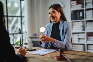 Lawyer smiling and discussing contract details with client in office