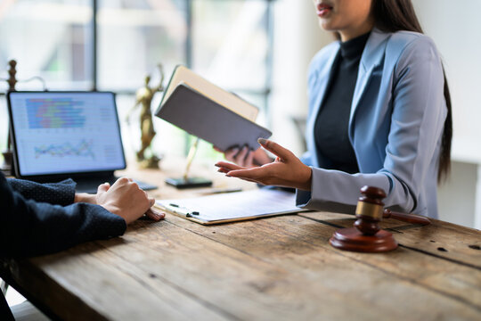 Lawyer holding document is explaining legal advice to client in office