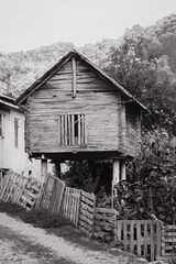 Rustic wooden stilt barn in Georgian countryside with weathered planks and green surroundings, perfect for travel and heritage concepts