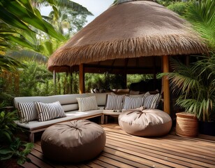 a cozy outdoor seating area with bean bags and striped pillows on a wooden deck in front of a thatched roof hut surrounded by lush greenery