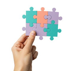 A human hand holds up a perfectly assembled nine-piece jigsaw puzzle with pastel-colored components, symbolizing concepts of problem-solving, teamwork, and completion against a dark background.