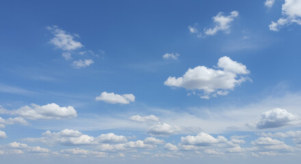 Expansive Blue Sky with Scattered Fluffy Cumulus Clouds on a Bright Day.