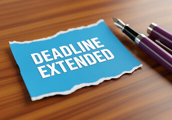 A blue note announces a deadline extension accompanied by a fountain pen on wooden surface
