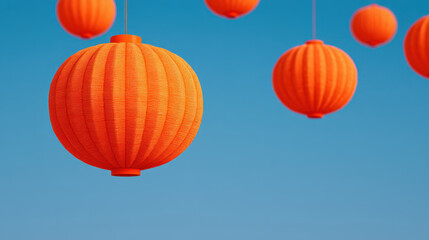Fototapeta premium Halloween craft ideas, Orange lanterns hang against clear blue sky creating bright craft ideas for festive and halloween decoration with vibrant