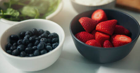 Strawberries, blueberries and bowl with fruit for diet, nutrition or natural organic meal prep. Closeup, vitamins and ingredients with fiber for healthy breakfast, vegetarian food or recipe in home