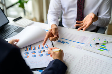 Business people analyzing financial charts and graphs discussing company growth and planning marketing strategies