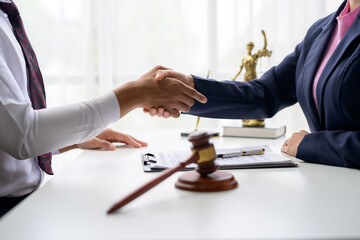 Lawyers shaking hands after signing contract in office