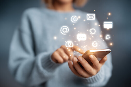 Woman using smartphone with glowing communication icons and notifications appearing, representing digital connectivity and online engagement. - Powered by Adobe