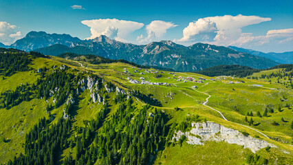 Aerial panoramic view of Velika Planina in Slovenia featuring vast green alpine pastures dotted...