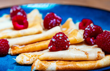 Pancakes with raspberries and condensed milk.