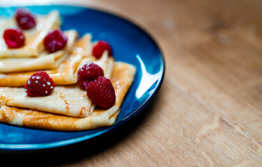 Pancakes with raspberries and condensed milk.
