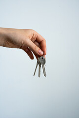 Woman holding three metal keys on a white background. Composition suitable for concepts of security, home, office, real estate, or access. Isolated on white for commercial, editorial, marketing use. 