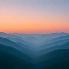 Obraz premium Layers of blue mountains fading into the distance under a soft sunrise sky.