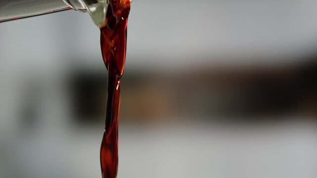 Asian Japanese soy sauce, Dark brown soy sauce pouring down into the glass bowl close up