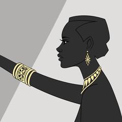 Arm of a black woman fully covered with gold bracelets, gradient grey
