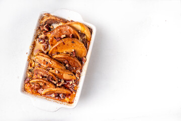 Tasty autumn Cinnamon Pecan Pancake Breakfast baked Casserole with honey. Fall seasonal recipe,  brunch snack for Thanksgiving morning, sweet simple dessert on white table with ingredients for cooking