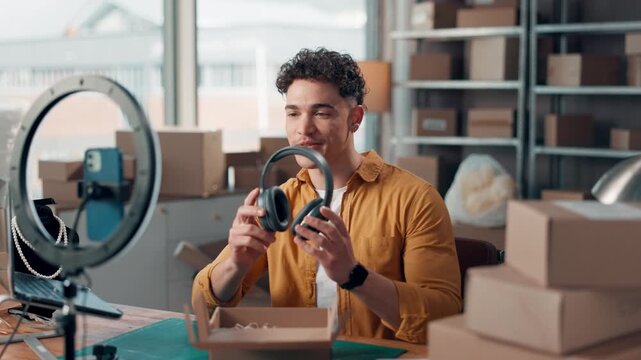 Man, ring light and filming with headphones of small business, review product and online shopping. Male person, phone and live streaming for ecommerce, marketing promotion and recording promotion