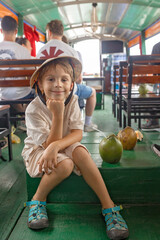 Fototapeta premium Happy european family, visiting Mekong river in Vietnam on a summer day, boat trip and local habits