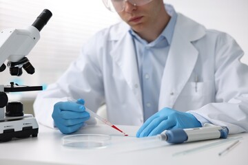 Medical analysis. Scientist working with blood sample in laboratory, closeup