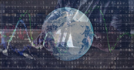 Typing man focusing on laptop keyboard in dark office, with globe, binary code and market charts