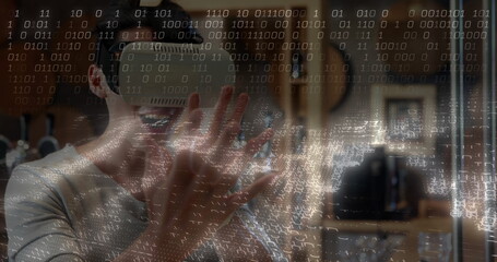 Gesturing adult male wearing VR headset using hand tracking in home studio, guitars, coding overlay