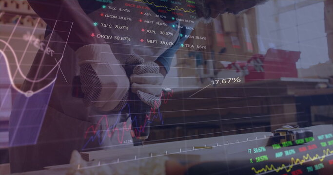 Drilling craftsman using handheld blue power drill into wood plank in workshop, stock data floating