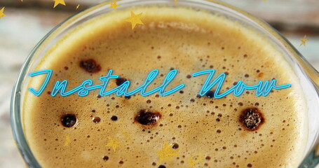 Showing glass coffee cup with frothy crema bubbles on counter with neon Install Now golden stars