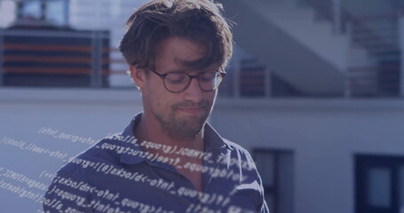 Standing developer analyzing floating code overlay on rooftop terrace, with round eyeglasses