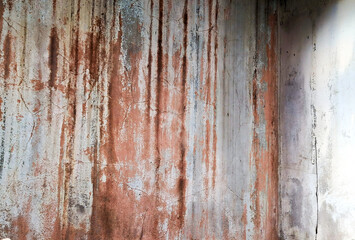 Weathered brown concrete wall with a rough, grungy texture and peeling paint
