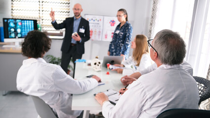 Fototapeta premium Hospital staff at the presentation of a groundbreaking brain surgery. A group of scientists in white lab coats are sitting at a table