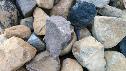 Rough natural river stones in various sizes and colors piled together for construction use