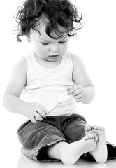 Curly haired toddler applying lotion or cream