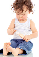Curly haired toddler applying lotion or cream