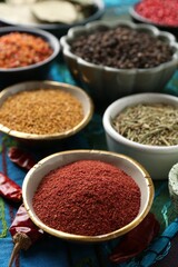 Different aromatic spices on blue tablecloth, closeup