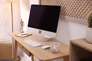 Fototapeta premium Stylish workplace with wooden desk, computer and stationery at home office, closeup. Interior design