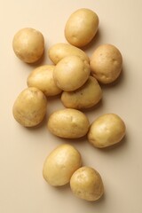 Fresh raw potatoes on beige background, top view